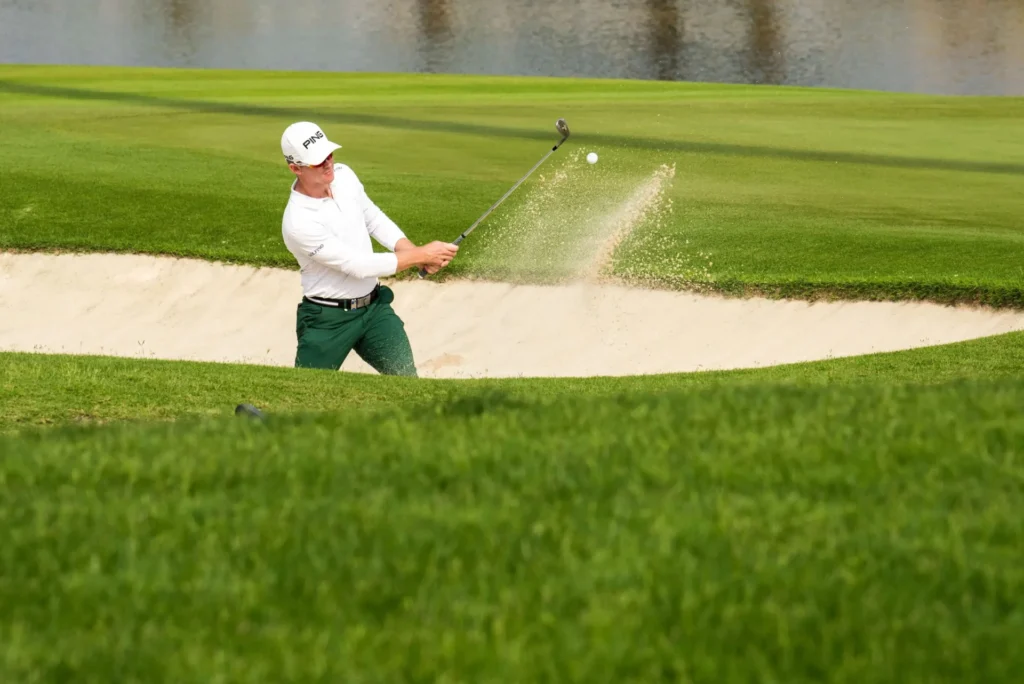 A man hitting a golf ball.